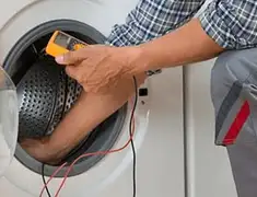 Washing machine repair technician testing a front-load washer with diagnostic tools in Bakersfield, CA